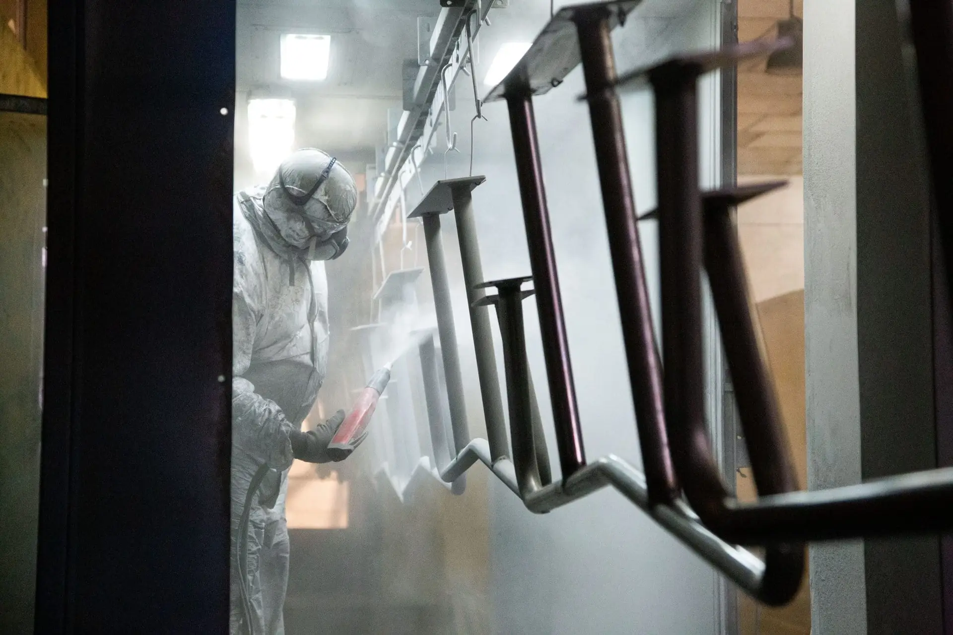 Aplicación de pintura sobre piezas metálicas en la cabina de Neolaser
